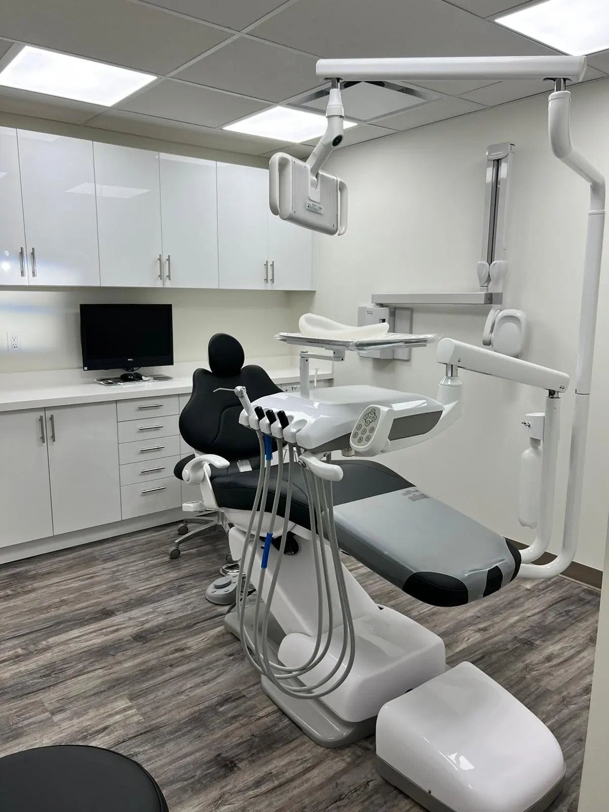 UBCS | Dental construction serivces HVAC the image showcase  A modern dental room featuring a chair and desk, designed for optimal patient care and equipped with an HVAC system.